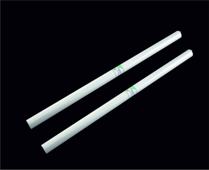 Puede incluir: Dos rollos de papel blancos con texto verde en el lateral. El texto dice "Self-Adhesive Backing".