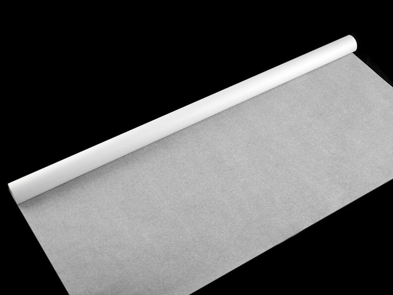 Puede incluir: Un rollo de papel pergamino blanco, desenrollado sobre un fondo negro.