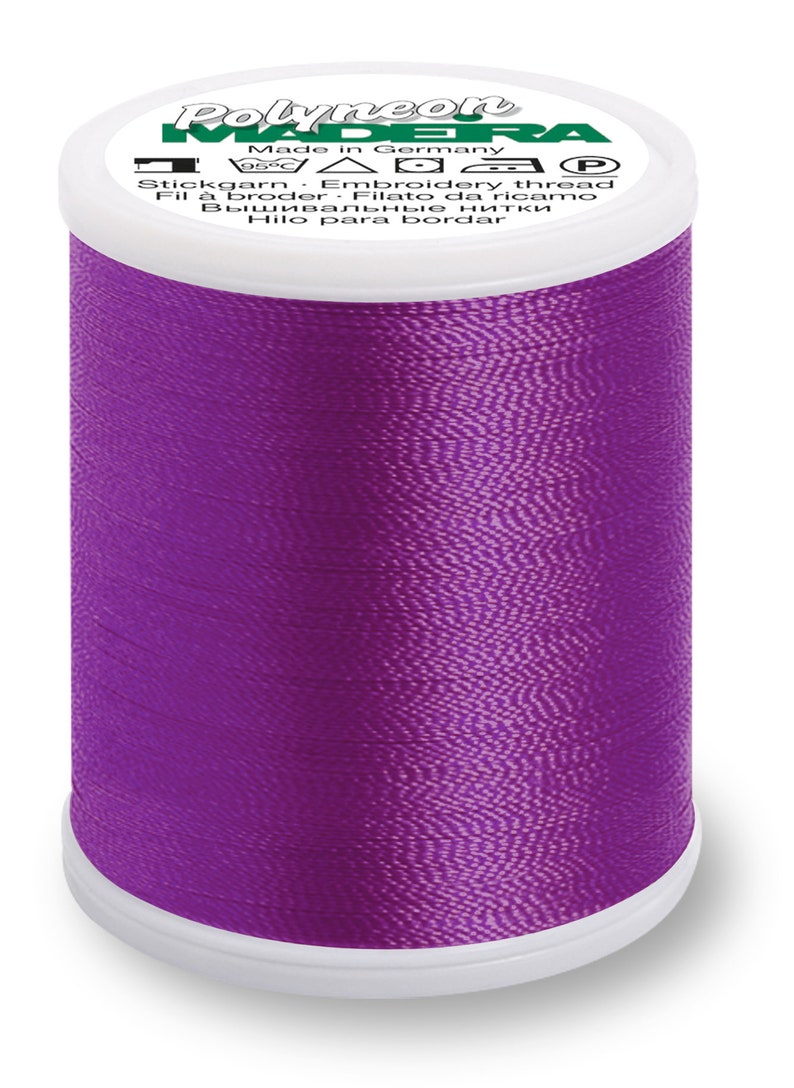 Puede incluir: Una bobina de hilo de bordar de color morado con la marca "Polyneon Madeira" y el texto "Made in Germany" en la etiqueta.