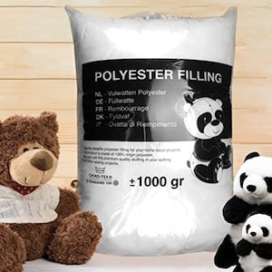 Op de afbeelding: Een witte zak met polyester vulling voor knutsel- en interieurprojecten. De zak is gelabeld "Polyester Filling" en bevat het gewicht "±1000 gr".