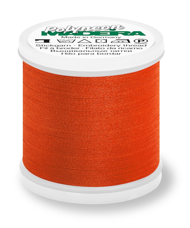 May include: A spool of orange embroidery thread labeled "Polyneon Madeira" with the text "Made in Germany" and care instructions.
