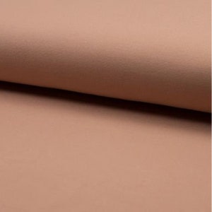 May include: A close-up of a soft, peach-colored fabric with a subtle textured surface.