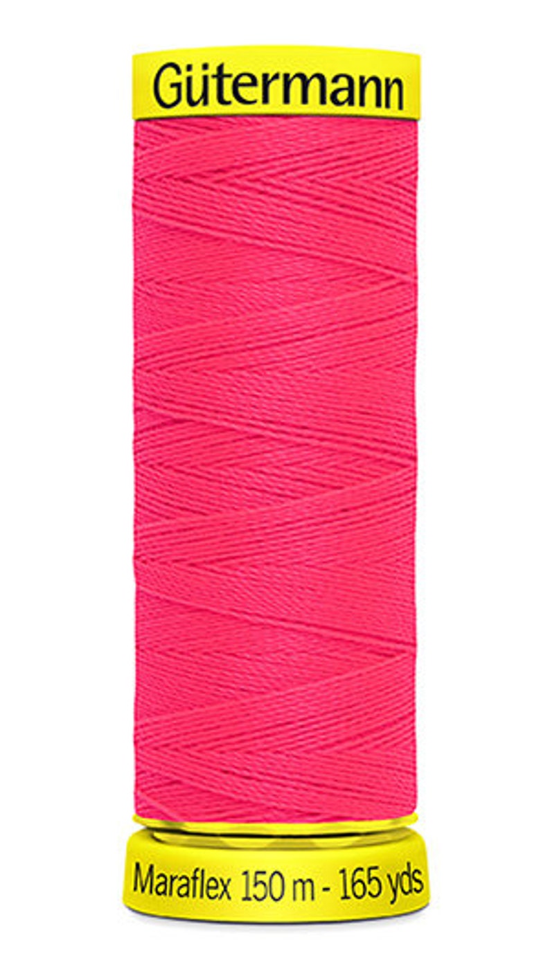 May include: A spool of pink G&uuml;termann Maraflex thread with a yellow label that reads "G&uuml;termann Maraflex 150 m - 165 yds".