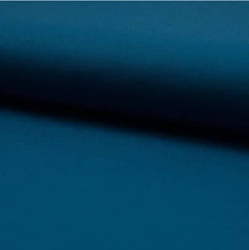 May include: A solid teal blue fabric swatch. The fabric has a smooth, slightly textured surface.