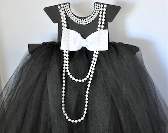 Centro de mesa alto de tutú blanco y negro con perlas y lazos para baby showers, despedidas de soltera y fiestas de cumpleaños.