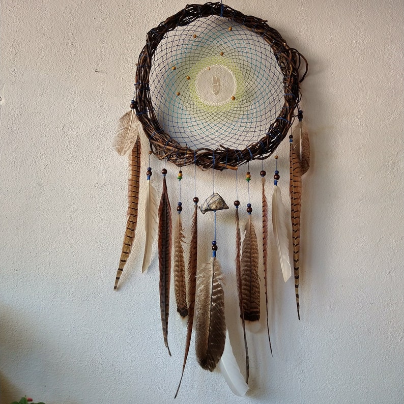 rustic and creative dream catcher with lots of feathers and stones
