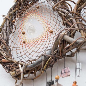 Pu&ograve; includere: Un acchiappasogni fatto a mano con una cornice a forma di cuore realizzata con rami intrecciati. La rete interna sfuma dall'arancione al giallo, con perline di legno e cristalli pendenti. Decorazione murale in stile boh&eacute;mien.