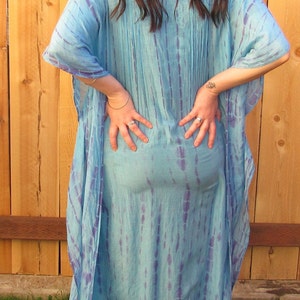 May include: A long, flowing blue and purple tie-dye kaftan dress with a loose, comfortable fit.