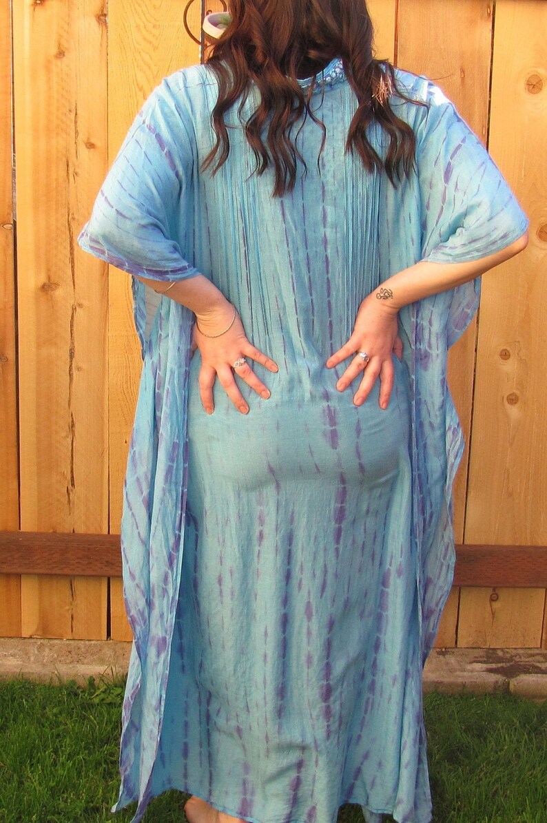 May include: A long, flowing blue and purple tie-dye kaftan dress with a loose, comfortable fit.