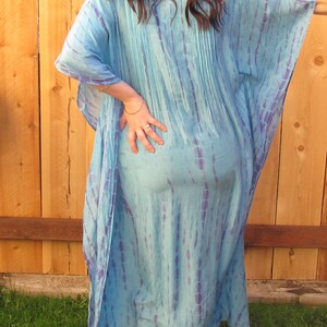 May include: A long, flowing blue and purple tie-dye kaftan dress. The dress has a loose, comfortable fit and is perfect for a casual summer look.