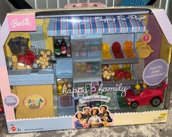 May include: Barbie "Shopping Fun" playset featuring a miniature supermarket with shelves, a checkout area, and a red toy car. The set includes various toy food items and the text "happy family Neighborhood".