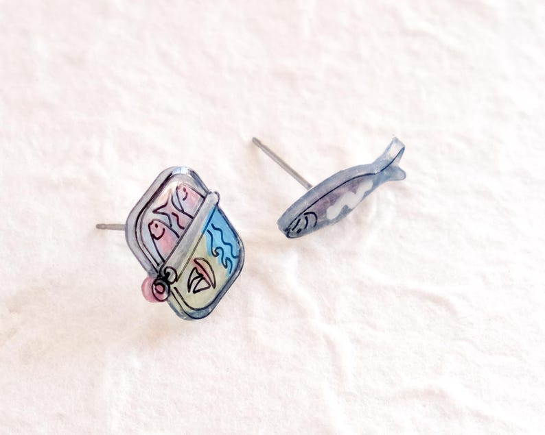a pair of earrings sitting on top of a white surface