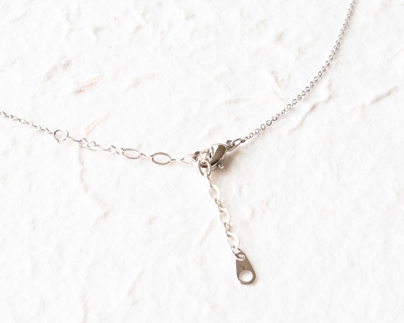 May include: A silver chain necklace with a lobster clasp closure.