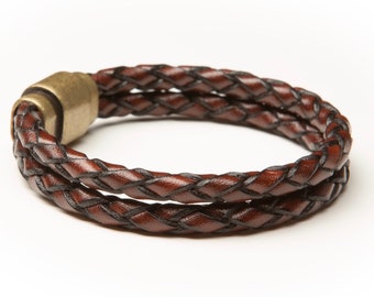 May include: A brown leather bracelet with a braided design and a brass clasp.