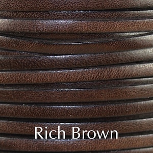 May include: Close-up of a spool of rich brown leather cord. The cord is smooth and supple, with a slightly textured surface.