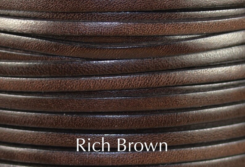 May include: Close-up of a spool of rich brown leather cord. The cord is smooth and supple, with a slightly textured surface.