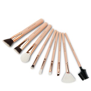 Op de afbeelding: Set van acht make-upkwasten met ros&eacute;gouden accenten en houten handvatten. De handvatten zijn gelabeld "Beaute Galleria".