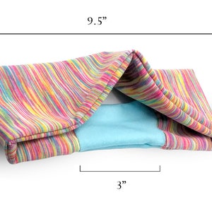 May include: A colorful striped fabric cat bed with a blue lining. The bed measures 9.5 inches long, 3.25 inches high, and 3 inches wide.
