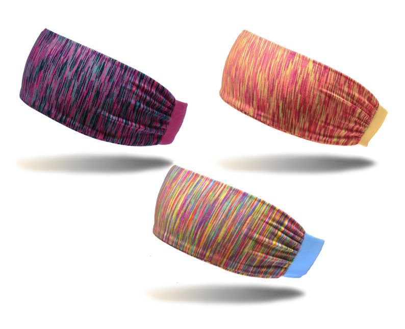May include: Three colorful headbands with different patterns. The first headband is pink and black, the second is yellow and red, and the third is rainbow.