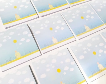 May include: A stack of cards with a blue sky background, white clouds, and a yellow balloon. The cards have the text "Just let me love you" written on them.