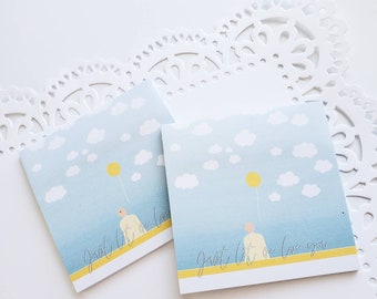 May include: Two blue and white cards with a yellow stripe and the text "Just let me love you" in grey script. The cards feature a simple illustration of a person standing under a yellow balloon in a blue sky with white clouds.