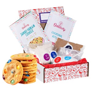 Puede incluir: Un kit de horneado Baketivity para hacer galletas grandes de chispas de chocolate. El kit incluye una caja con un patrón rojo y blanco, una bolsa de harina, una bolsa de azúcar, una bolsa de chispas de chocolate y una tarjeta de receta. El kit también incluye un conjunto de chispas de colores.