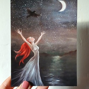 May include: A painting of a woman with red hair and a white dress, arms raised towards a starry night sky with a crescent moon. A black bird flies above. The artwork is signed with the website Magicpaintings.com.