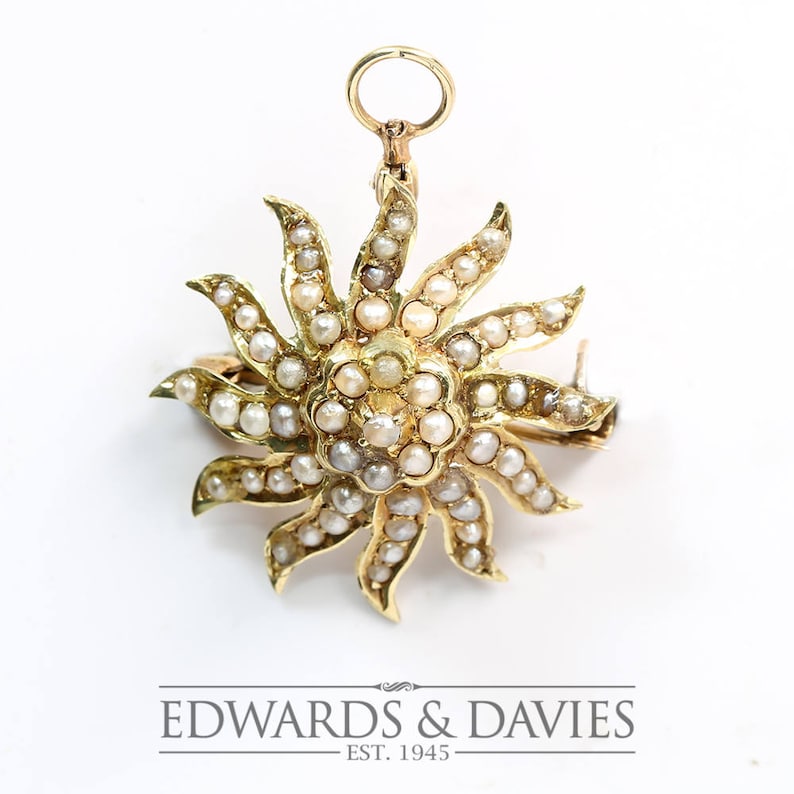 May include: A gold sunburst brooch with a pearl and diamond design. The brooch has a loop at the top for attaching to a chain.