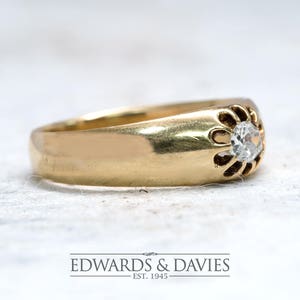 Pode incluir: Um anel de banda de ouro com um &uacute;nico diamante redondo engastado em um design floral.
