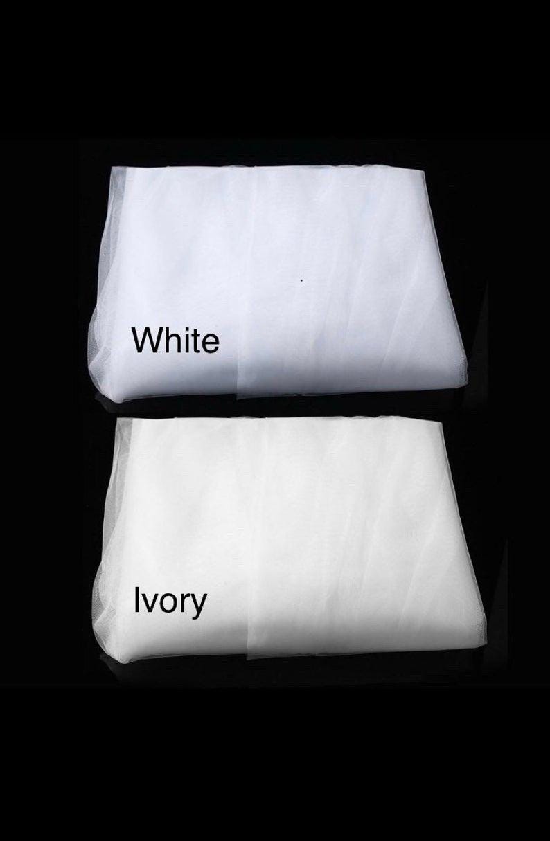 May include: Two pieces of white tulle fabric, one labeled "White" and the other labeled "Ivory".