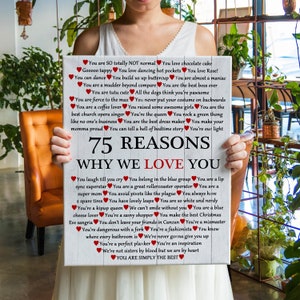 May include: A white wooden sign with red hearts and the text "75 Reasons Why We Love You" in black. The sign lists 75 reasons why someone is loved, including "You are a great rollercoaster operator", "You are a super mom", and "You are simply the best".