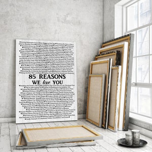 May include: A white canvas print with black text listing 85 reasons why someone is loved. The text is in a heart shape and includes phrases like "Driving Tennessee Ernie while sitting on your lap" and "Teaching me how to use a rifle for hunting deer".