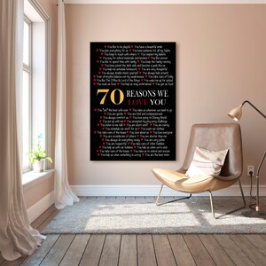 May include: A black and gold framed print with a white background and red hearts. The print lists 70 reasons to love someone, with each reason written in a red heart. The print is titled "70 Reasons We Love You".