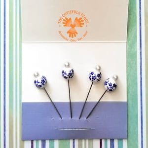 Rechte pinnen met blauwe bloemen op witte keramische parel. Deze decoratieve pinnen zijn een geweldig cadeau voor borduursters, quiltsters en tuinliefhebbers
