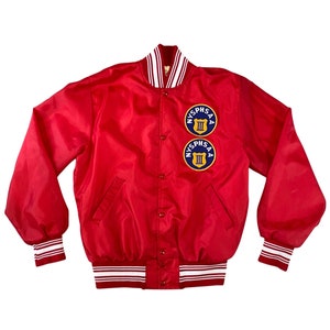 May include: Red satin varsity jacket with white and red striped trim. The jacket has two embroidered patches on the left chest that say "NYSPHSAA III".