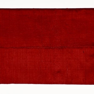 May include: A rectangular clutch bag in a deep, rich red color. The surface of the bag features a visible, fine-textured weave pattern throughout the fabric, creating a subtle grid-like appearance across the entire exterior of the accessory.