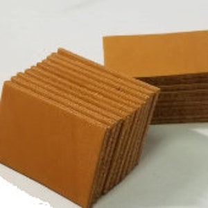 May include: A stack of ten brown leather squares, each measuring approximately 10 cm by 10 cm.