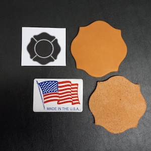 May include: An assortment of items including a black and white firefighter Maltese cross stencil, two tan leather patches, and a rectangular sticker with the American flag and the text "MADE IN THE U.S.A."