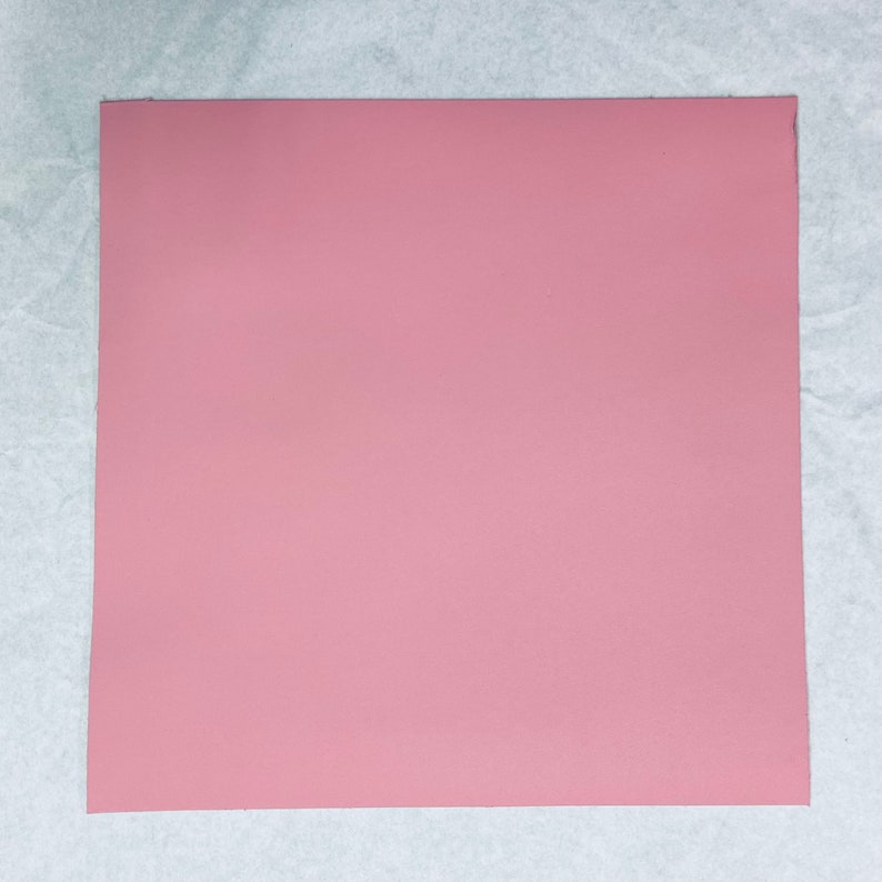 May include: A solid pink sheet of paper.