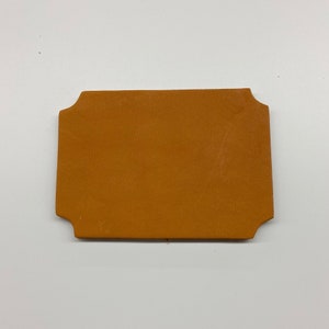 May include: A brown leather tag with rounded corners.