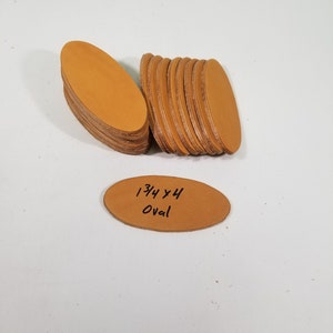 May include: A stack of 10 tan leather oval shapes, each measuring 1 3/4 inches by 4 inches. The text "1 3/4 x 4 Oval" is written on one of the leather pieces.