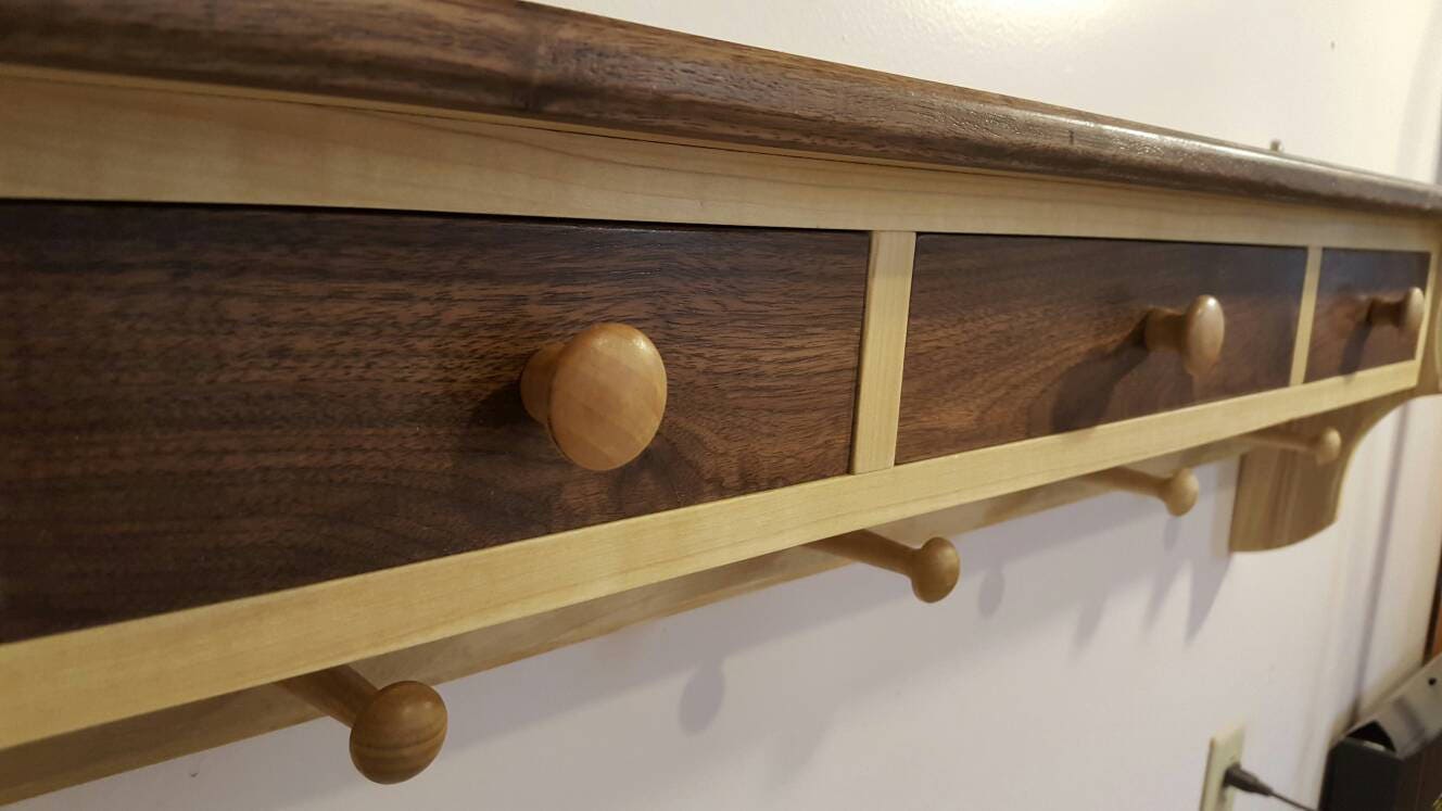 Shelving unit made from walnut and poplar with 3 drawers and 4 pegs