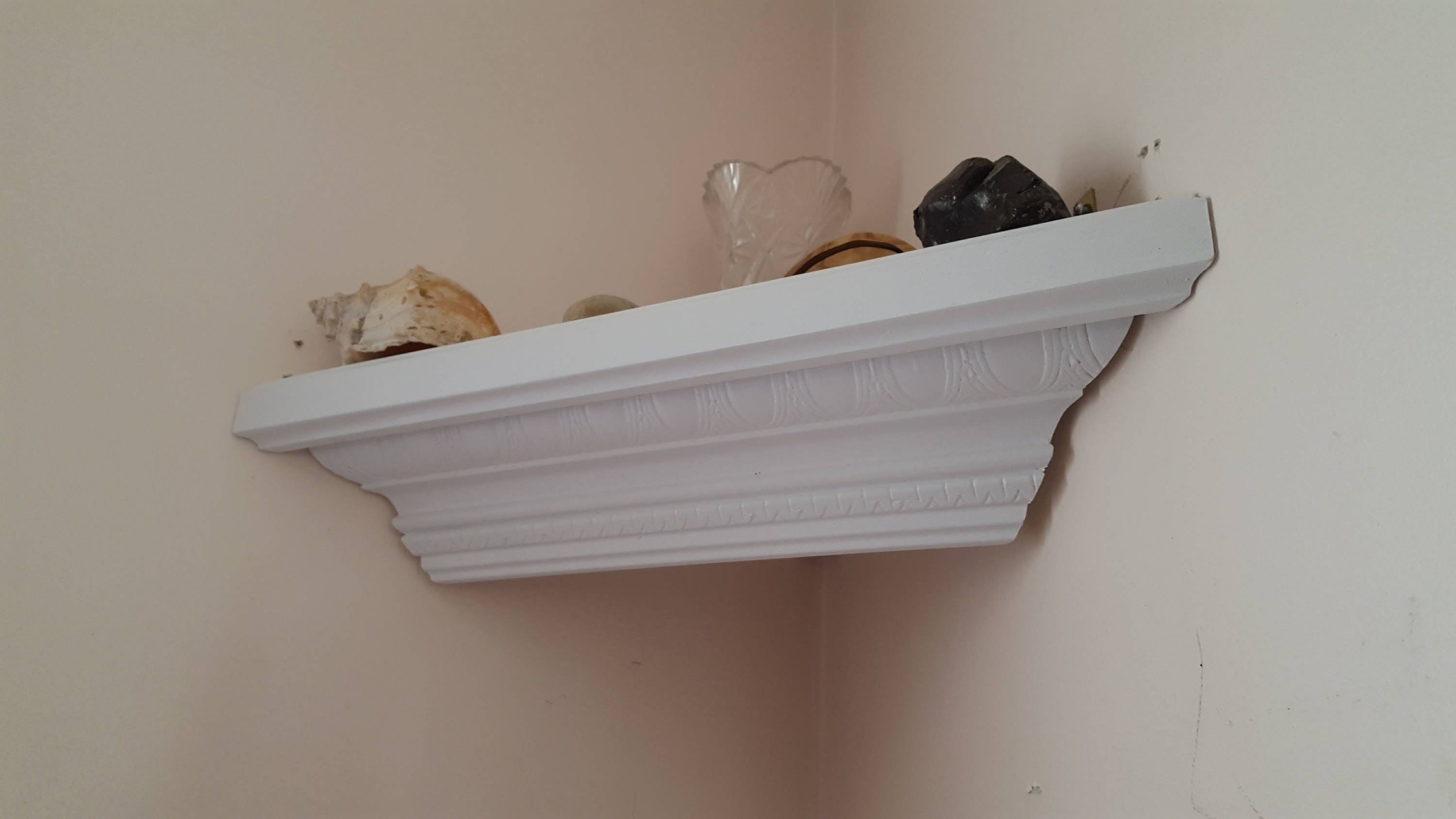 Corner shelf made from decorative crown molding in white
