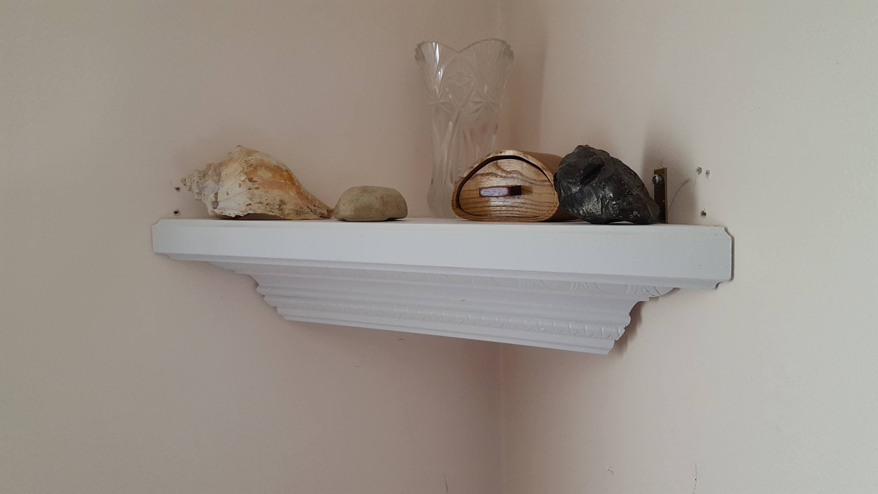 Corner shelf made from decorative crown molding in white