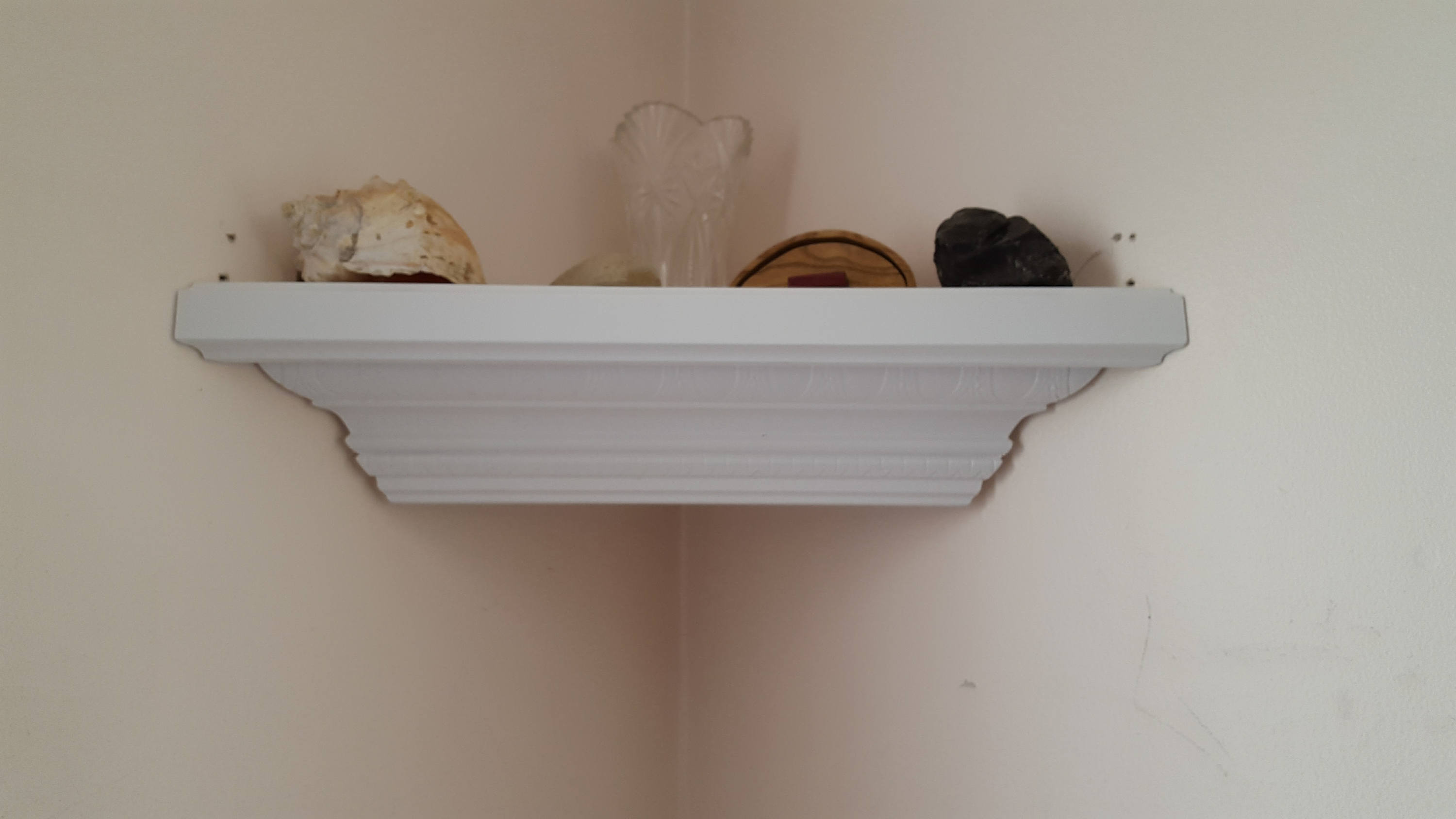 Corner shelf made from decorative crown molding in white