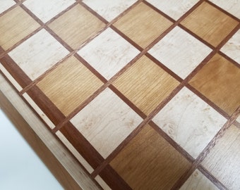 Chessboard made from cherry,  birdseye maple,  mahogany,  and ipe with 2 and an 8th inch squares .The board is finished in satin