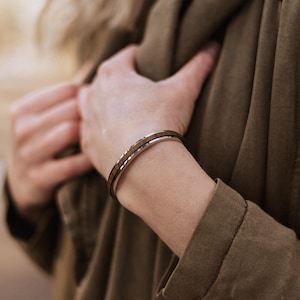 Peut inclure: Un bracelet jonc en argent et bois avec une finition polie.