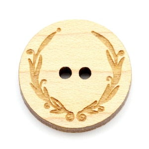 Può includere: Un bottone rotondo in legno con un motivo floreale inciso sulla superficie. Il bottone ha due fori per cucire.