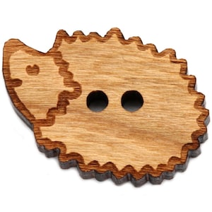 Könnte beinhalten: Ein Knopf aus Holz in Form eines Igels mit zwei Löchern zum Nähen. Der Knopf ist braun und hat ein detailliertes Design.