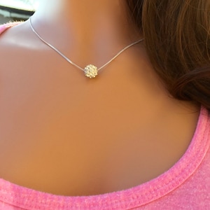 May include: A silver chain necklace with a small, sparkly, round pendant.